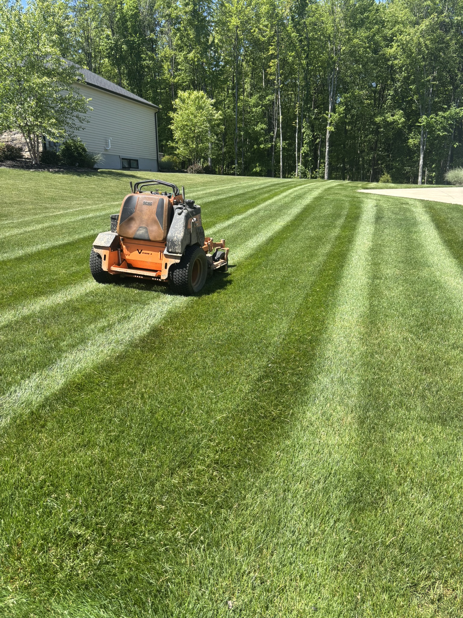 Zero-turn mower cutting crisp stripes into a green lawn