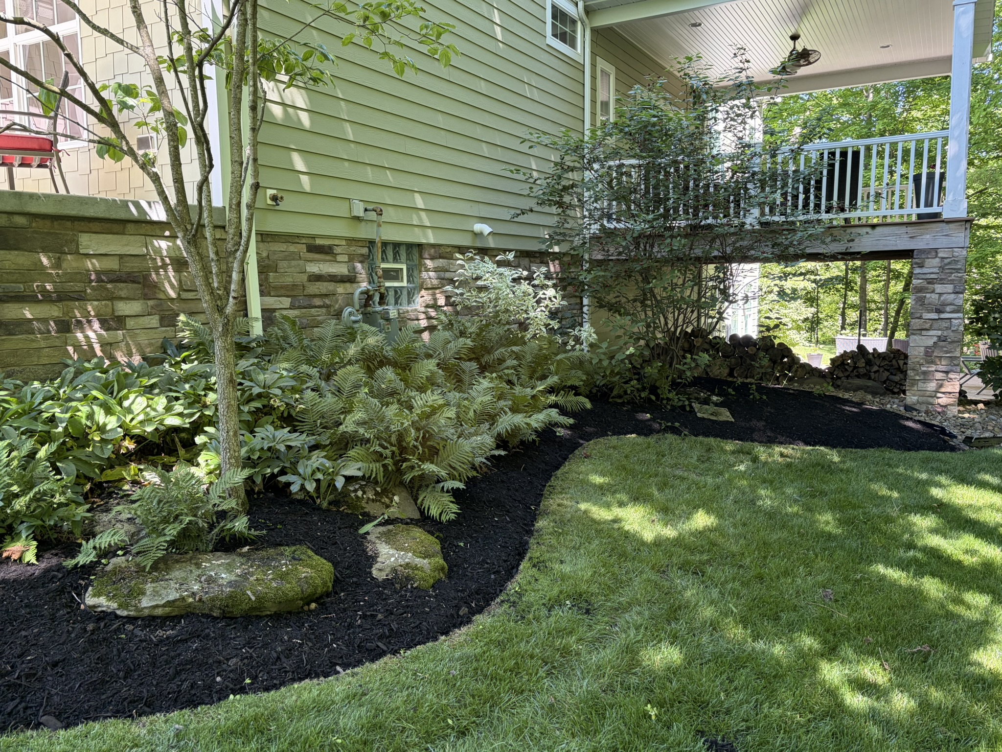 Fresh mulch landscaping wrapping a backyard deck