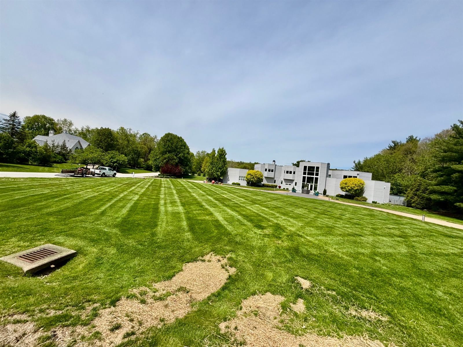 Wide front lawn mowed in long stripes in front of a modern house