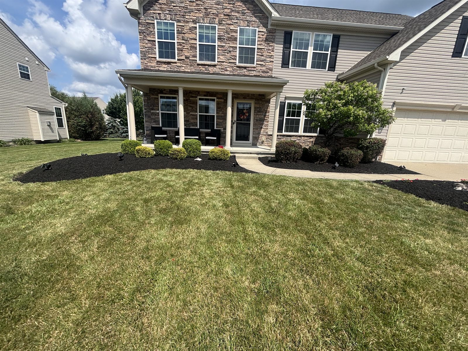 Thick green lawn with fresh mowing stripes in front of a house