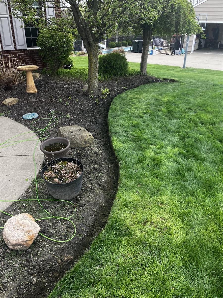 Crisp curved edge between the lawn and a fresh bed