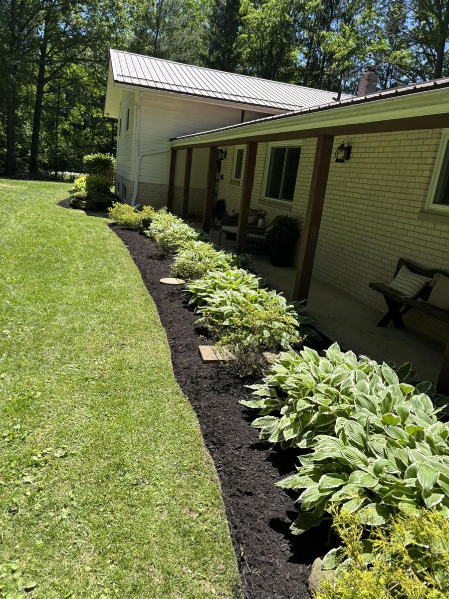 Fresh mulch bed with hostas along a ranch home